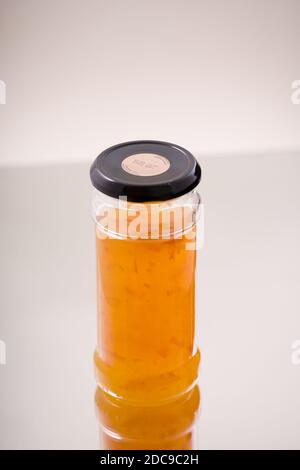 Pot de marmelade maison tourné sur fond blanc dans le studio. Banque D'Images