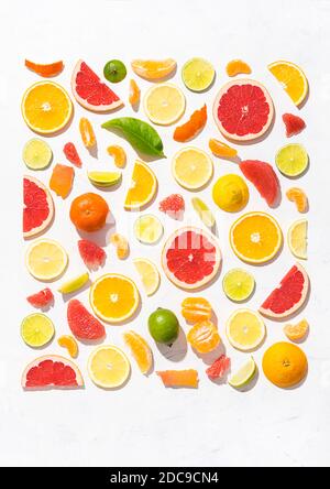 Motif coloré composé de tranches d'agrumes, d'orange, de citron, de lime et de pamplemousse. Décoration de gin concept sur fond blanc Banque D'Images