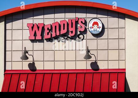 Affiche et logo du restaurant de restauration rapide Wendy's au-dessus de l'entrée sur un mur extérieur Banque D'Images