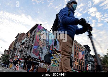 New York, États-Unis. 19 novembre 2020. Un homme sur un scooter motorisé passe devant une fresque en l'honneur de la juge de la Cour suprême Ruth Bader Ginsburg (RGB), peinte par l'artiste connue sous le nom D'ELLE, sur le côté d'un immeuble de trois étages East Village, New York, NY, le 19 novembre 2020. Ginsburg a été juge associée de la Cour suprême des États-Unis de 1993 à sa mort le 18 septembre 2020. (Anthony Behar/Sipa USA) crédit: SIPA USA/Alay Live News Banque D'Images