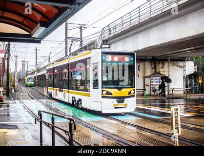 Nagasaki, Japon - 2 novembre 2020 : tramway jaune et blanc le jour des pluies à Nagasaki Banque D'Images