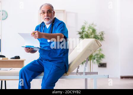 Médecin senior prenant des notes dans la clinique Banque D'Images