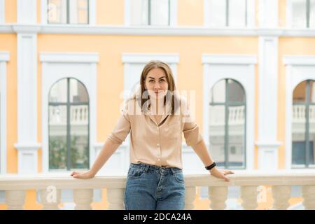 Belle fille se posant volontiers pendant que la galerie marchande de marche dans la bonne humeur. Portrait de mode de vie Banque D'Images