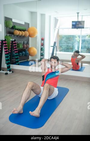 Un jeune homme barbu s'assoit dans la salle de sport Banque D'Images