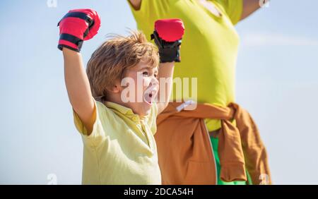 Petit garçon faisant de l'exercice de boxings avec grand-père. Le père forme sa boxe de fils. Petit sportif de garçon à l'entraînement de boxe avec entraîneur. Homme sportif Banque D'Images