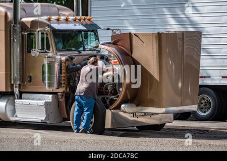 Un conducteur de chariot expérimenté vérifie le bon fonctionnement du moteur pendant un faites la descente sur du diesel industriel classique marron pour engins de forage de grande taille caisse semi-camion Banque D'Images
