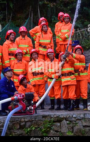 (201120) -- RONGSHUI, 20 novembre 2020 (Xinhua) -- Le 19 novembre 2020, des volontaires féminins participent à un exercice d'incendie sous la direction de pompiers professionnels au village de Wuying, un village isolé habité par le groupe ethnique Miao à la frontière entre la région autonome de Guangxi Zhuang dans le sud de la Chine et la province de Guizhou dans le sud-ouest de la Chine. Alors que les maisons de style architectural local du village sont soutenues par une structure boisée, une équipe de femmes pompiers volontaires est formée pour protéger leur village, car la plupart des jeunes et des hommes d'âge moyen s'aventurent en tant que migrants. (Xinhua/Huang Xiaobang) Banque D'Images