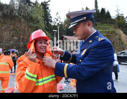 (201120) -- RONGSHUI, 20 novembre 2020 (Xinhua) -- Le 19 novembre 2020, une volontaire porte des engins de lutte contre les incendies avec l'aide d'un pompier professionnel au village de Wuying, un village isolé habité par le groupe ethnique Miao à la frontière entre la région autonome de Guangxi Zhuang dans le sud de la Chine et la province de Guizhou dans le sud-ouest de la Chine. Alors que les maisons de style architectural local du village sont soutenues par une structure boisée, une équipe de femmes pompiers volontaires est formée pour protéger leur village, car la plupart des jeunes et des hommes d'âge moyen s'aventurent en tant que migrants. (Xinhua/Huang Xiaobang) Banque D'Images