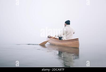Vue arrière de l'homme pagayant canoë en hiver, espace copie Banque D'Images