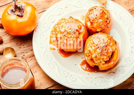 Persimmon farci de granola et de sauce caramel.Persimmon cuit savoureux. Banque D'Images