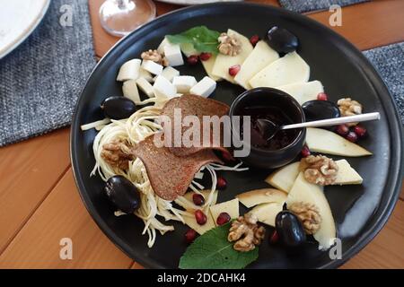 Divers fromages sur une assiette noire dans le café Banque D'Images