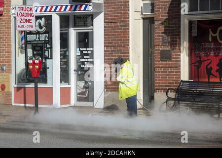 MORGANTOWN, ÉTATS-UNIS - 17 juin 2020 : homme nettoyant le trottoir en ville à l'aide d'une machine à pression d'eau Banque D'Images