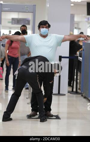 Non exclusif: CANCUN, MEXIQUE - NOVEMBRE 19: Une personne porte un masque de protection pendant l'enregistrement des bagages avant de monter à bord de l'avion à Cancun International Banque D'Images