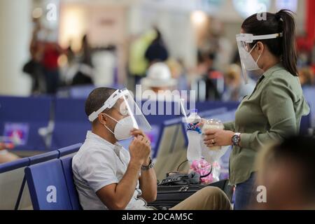 Non exclusif: CANCUN, MEXIQUE - NOVEMBRE 19: Une personne porte un masque de protection pendant qu'elle attend de monter à bord de l'avion à l'aéroport international de Cancun le novembre Banque D'Images