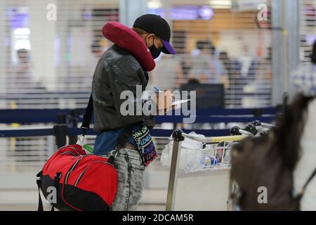 Non exclusif: CANCUN, MEXIQUE - NOVEMBRE 19: Une personne porte un masque de protection pendant qu'elle attend de monter à bord de l'avion à l'aéroport international de Cancun le novembre Banque D'Images