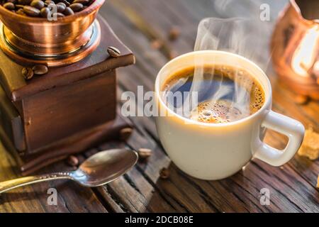 Café toujours vie. Tasse chaude de café et moulin à café à l'ancienne et de cizve. Banque D'Images