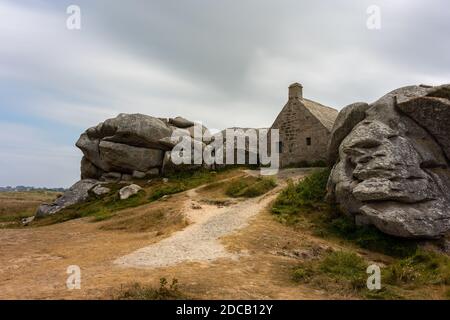 Maison entre rochers à Meneham, sur la côte atlantique dans le nord de la Bretagne (France), jour nuageux en été Banque D'Images