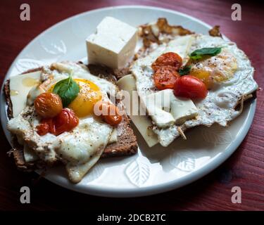 Œufs frits avec tomates et basilic, style méditerranéen Banque D'Images