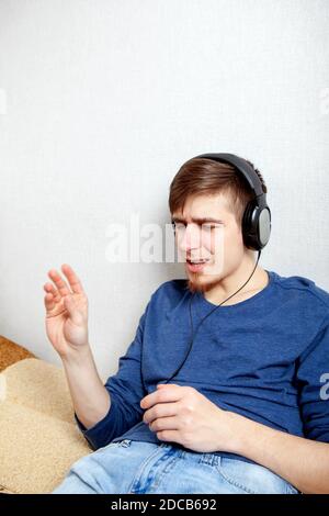 Jeune homme dans le casque écouter la musique et Chant Banque D'Images