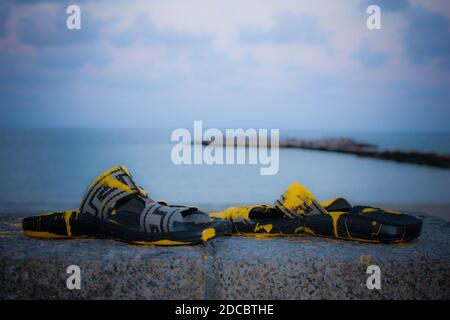 Poncer les chaussures avec de la peinture jaune, sur la rive Banque D'Images