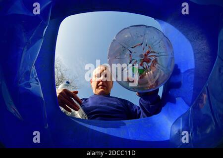 homme mettant des bouteilles en plastique dans la poubelle de recyclage ellerton yorkshire royaume-uni Banque D'Images