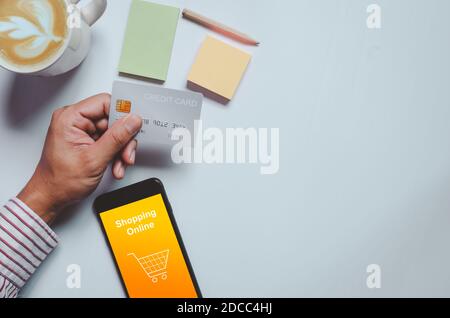 Homme d'affaires tenant la carte de crédit.achats en ligne, marketing d'affaires par le biais du paiement électronique avec smartphone.vue du dessus et espace de copie. Banque D'Images