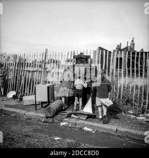 Les enfants jouent sur un orgue sur le côté de la route de Vallance Road dans l'est de Londres dans les années 1950, après avoir été au marché de Whitechapel. Les Twins de Kray vivaient au 178, chemin Vallance. Banque D'Images