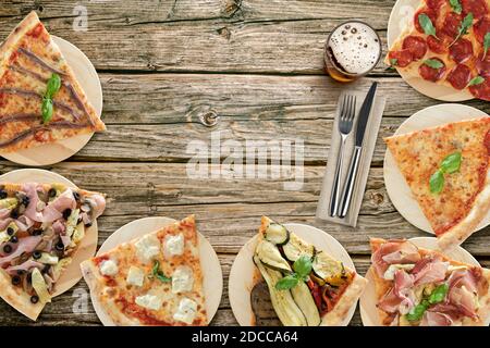 Vue de dessus de la variété de tranches de pizza sur des planches à découper en bois avec couverts Banque D'Images