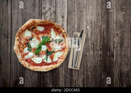 Vue de dessus de la pizza sur une table en bois avec des couverts Banque D'Images