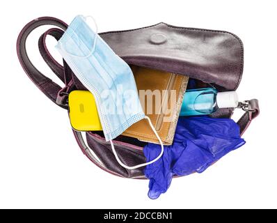 vue de dessus du sac pour femme avec masque de protection, assainisseur, gants, portefeuille et smartphone isolés sur fond blanc Banque D'Images