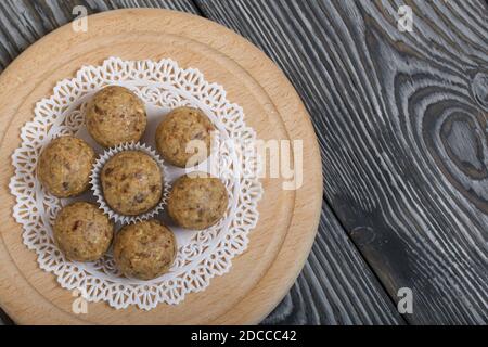 Bonbons aux fruits secs et aux flocons d'avoine. Sur les planches de pin noir. Gros plan. Banque D'Images