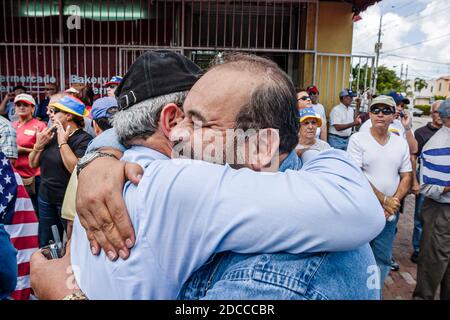 Miami Florida,Little Havana,hommes hispaniques,Calle Ocho protestation politique Fidel Castro Hugo Chavez,signe des bannières marching Vénézuéliens salutation Cubains Banque D'Images