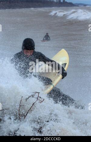 Paddle surf surfeur attendant d'entrer dans l'eau, Port Stanley Ontario Canada sur la rive nord du lac Érié. Banque D'Images