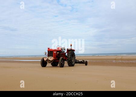 Ein Roter Traktor am Strand von Omaha Beach, Normandie, Frankreich Banque D'Images