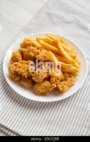 Beignets de poulet maison et frites sur une assiette, vue latérale. Banque D'Images