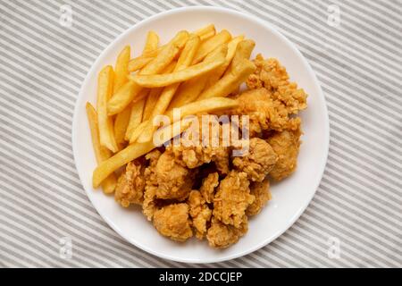 Beignets de poulet et frites faits maison sur une assiette de tissu, vue sur le dessus. Flat lay, vue de dessus. Gros plan. Banque D'Images