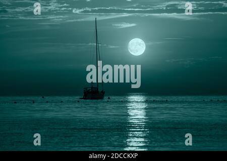Belle nuit mer Adriatique, yacht et pleine lune, Croatie. Paysage marin nocturne. Bannière tendance colorée en 2021 couleurs. Banque D'Images