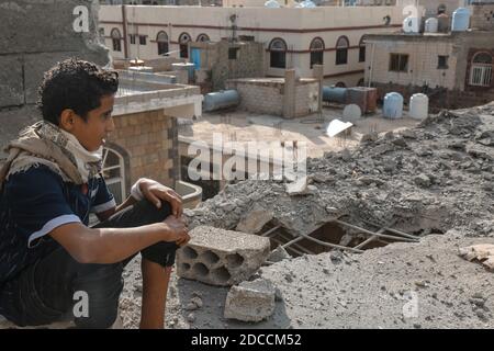 Taiz / Yémen - 22 août 2016 : UN enfant yéménite est assis sur les décombres de sa maison détruite par la guerre dans la ville yéménite. Banque D'Images