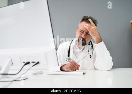 Vieil homme triste Docteur stress et douleur à l'ordinateur Banque D'Images