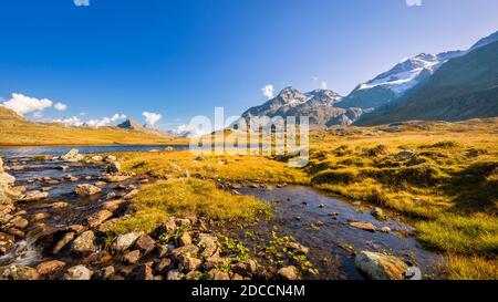 Le soleil se situe à Lej Pitschen, avec Lej Nair et Lago Bianco, l'un des trois lacs du col de Bernina. Banque D'Images