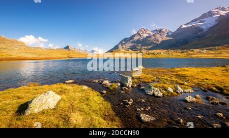 Le soleil se situe à Lej Pitschen, avec Lej Nair et Lago Bianco, l'un des trois lacs du col de Bernina. Banque D'Images