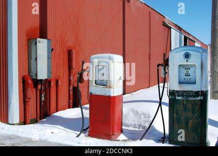 vieilles pompes à essence rouillée dans la neige par la grange Banque D'Images