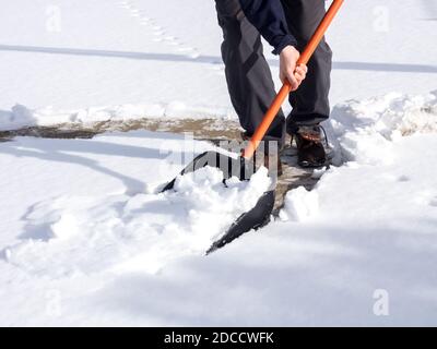 Gros plan sur le concept hivernal d'un ouvrier qui dépelle la neige du trottoir Banque D'Images
