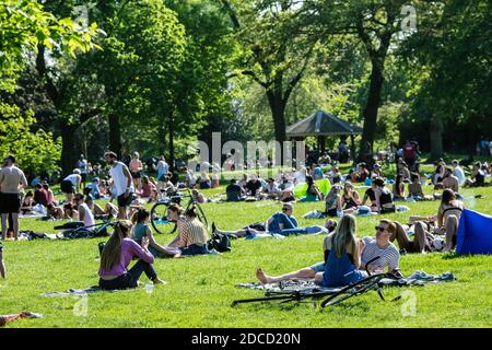 Personnes assises sur l'herbe à Victoria Park, Tower Hamlets à l'est de Londres, Royaume-Uni. Banque D'Images