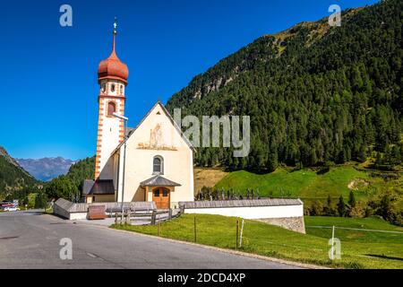 L'église Saint-Jacobus (en allemand : Jakobuskirche) de vent dans l'Ötztal (Tyrol, Autriche) est entourée de champs verdoyants et de montagnes puissantes Banque D'Images