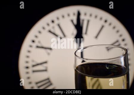 CÉLÉBRATION DE LA NOUVELLE ANNÉE, des verres levant avec du champagne avec l'horloge non focalisée Banque D'Images