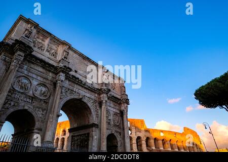 Arco di Constantino et Colosseum contre un ciel bleu clair au coucher du soleil - Rome, Italie Banque D'Images