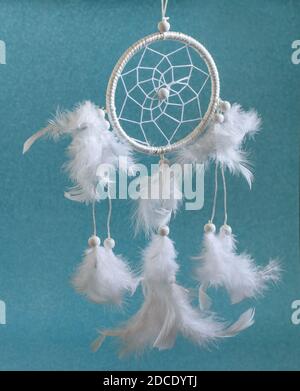 Magnifique roue magique blanche Dreamcatcher avec des plumes sur fond bleu. Amulette ethnique d'origine américaine, indienne et intérieure moderne d Banque D'Images