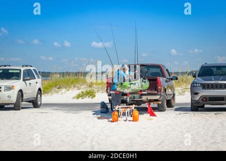 homme avec équipement de pêche et petit bateau sur remorque derrière 4x4 garés sur la plage à Biloxi Mississippi USA Banque D'Images