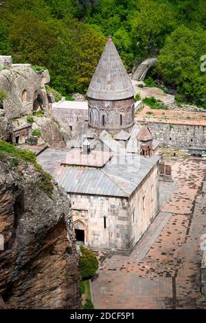 Monastère de Geghard, monastère médiéval dans la province de Kotayk en Arménie, partiellement sculpté dans la montagne adjacente, entouré de falaises. Banque D'Images